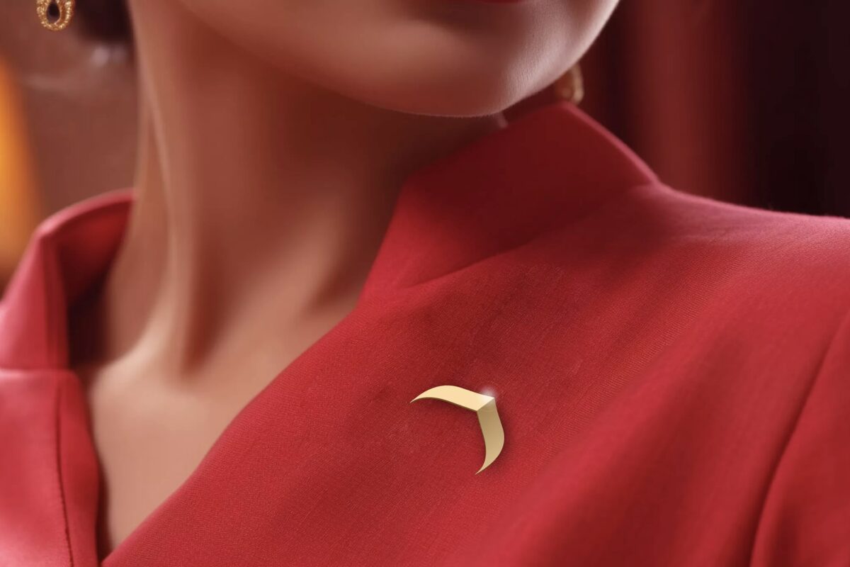 Close-up of a red Air India cabin crew uniform with the gold Air India emblem on the lapel
